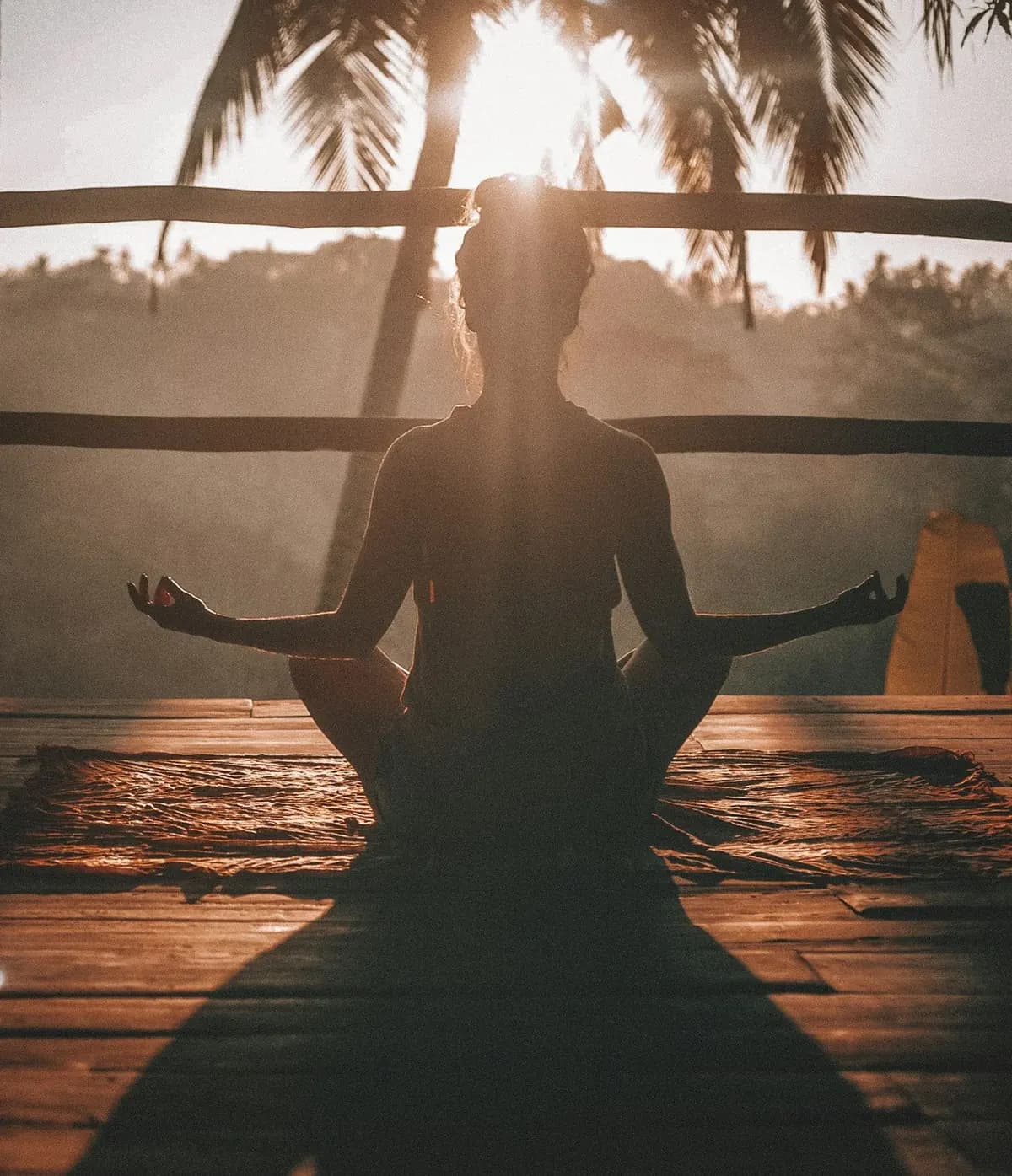 Pessoa meditando ao pôr do sol, em paz